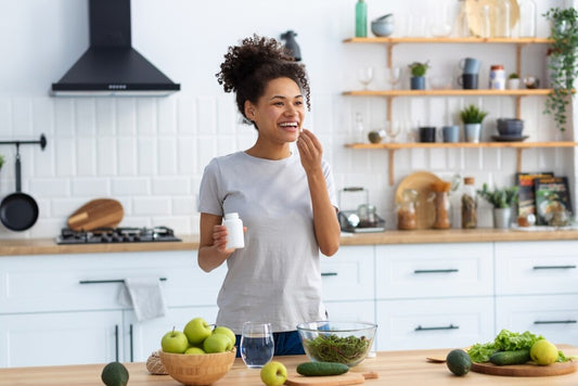 mulher na cozinha com o  gummy na mão 